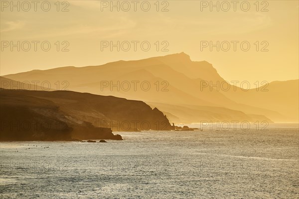 Beach Playa de la Pared with rocky coast at sunset