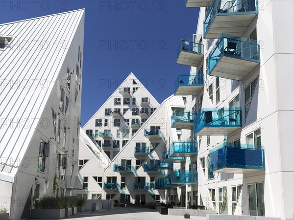 White residential complex with turquoise balconies against a blue sky