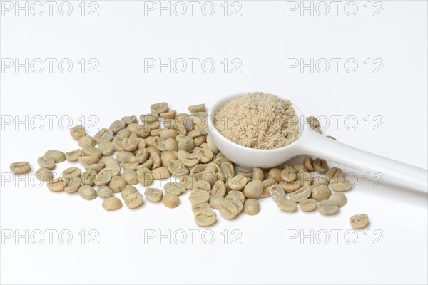 Green coffee beans and unroasted coffee powder in spoon