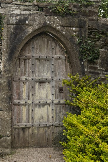 Old wooden door in the gardens of Victorian manor house Lanhydrock House