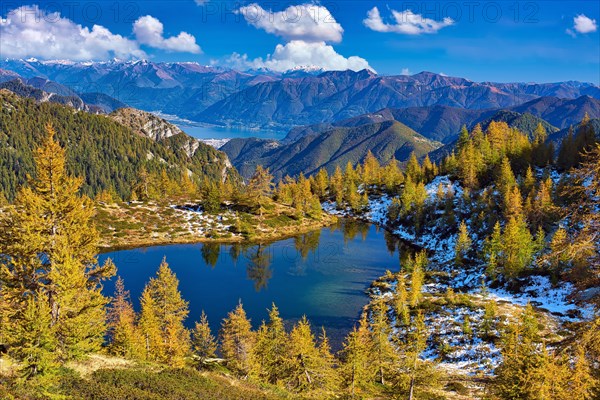 Mountain lake surrounded by autumnal larches