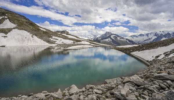 Friesenbergsee with Friesenberghaus in front of snowy mountains