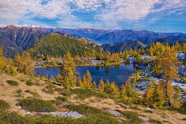 Mountain lake surrounded by autumnal larches