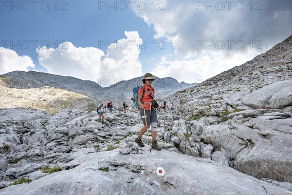 Four hikers in a landscape of washed-out karst rocks
