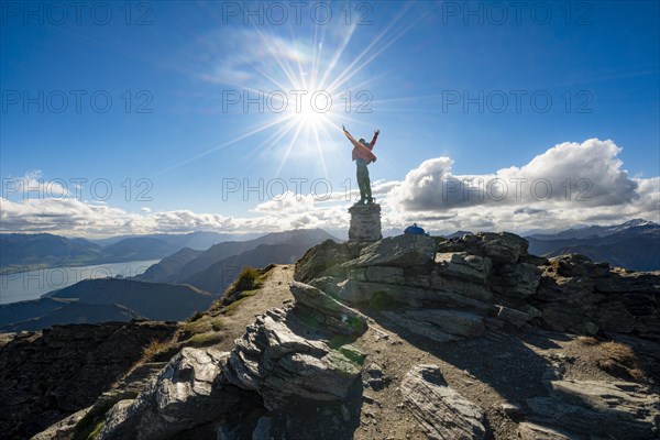 Hiker stretches out his arms in the air