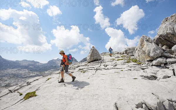 Two hikers in a landscape of washed out karst rocks