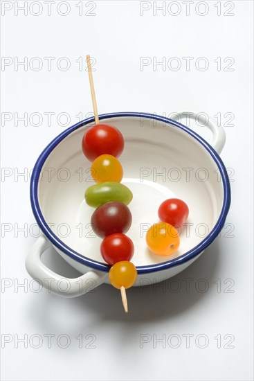 Various cherry tomatoes on wooden skewers on a bowl