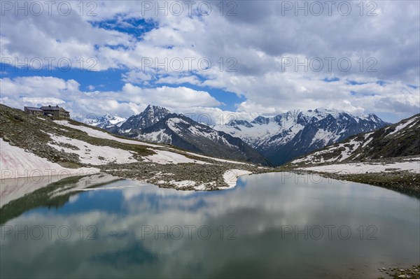 Friesenbergsee with Friesenberghaus in front of snow-covered mountains