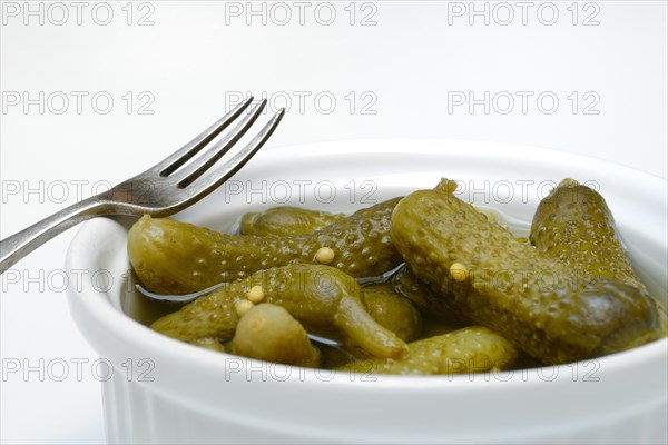 Cornichons in bowl with fork