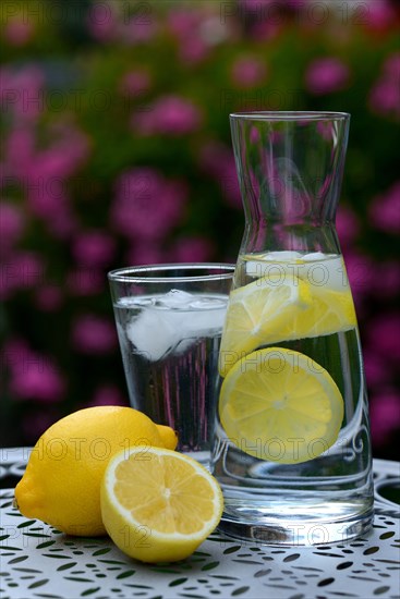 Lemon water in carafe and lemons