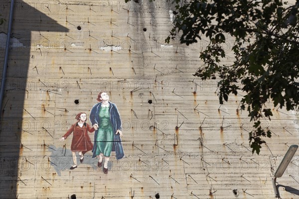 Woman with child fleeing from a bomb alarm