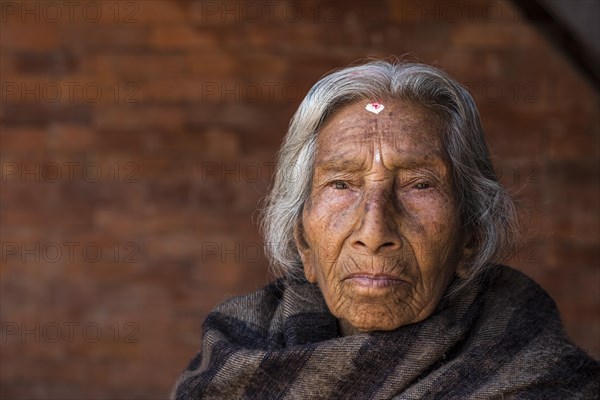 Portrait of an old Hindu woman wrapped in a blanket