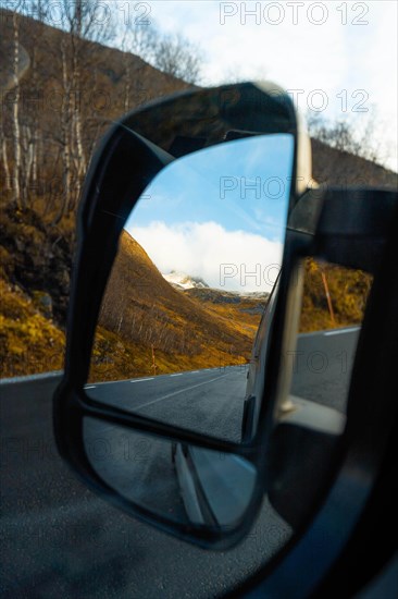 View through campervan mirror into autumnal fjord landscape