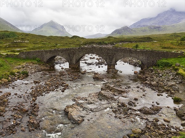 Old stone bridge Sligachan Bridge in front of Cuillin Hills mountains