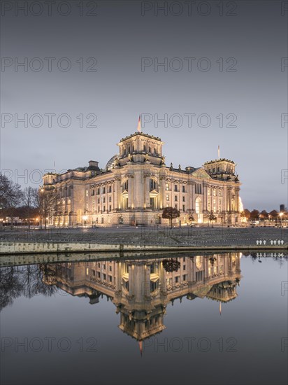 Reichstag with waving German flag at the Spree