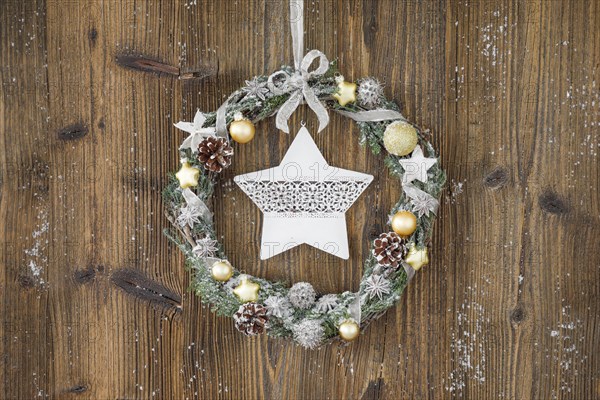 Christmas wreath on brown wooden wall with star