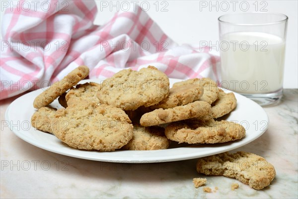 Oatmeal biscuits on plate and glass of milk