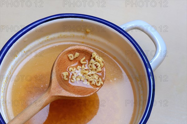 Cooking spoon with alphabet noodles and alphabet soup