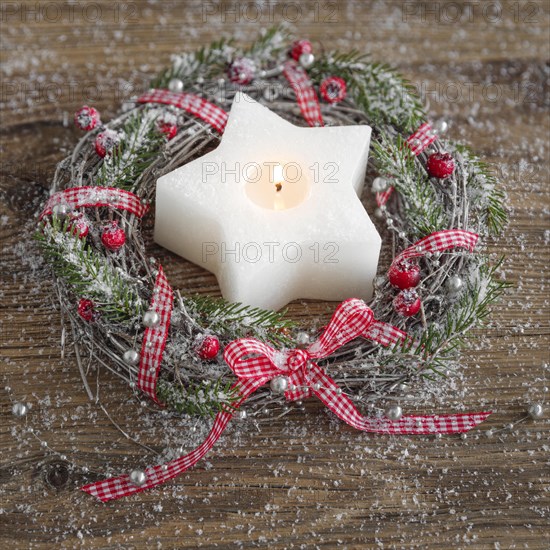 Natural advent decoration with wreath and star shaped candle