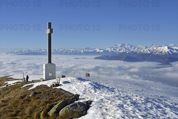 Summit cross of Monte Lema and sea of clouds over Lake Maggiore