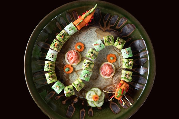 Sushi decorated in form of a dragon on round plate