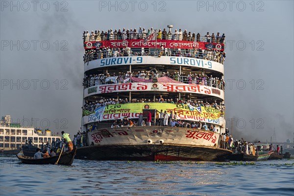 Overloaded passenger ferry with pilgrims on the Dhaka river