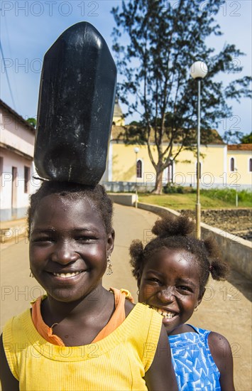 Friendly girls carrying a water canister