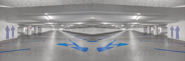Photomontage of an empty underground car park with blue arrows on the ground