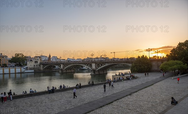 Waterfront Muelle de la sal at the river Rio Guadalquivir with bridge Puente de Triana
