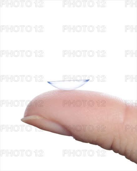 Contact lens on a finger against a white background