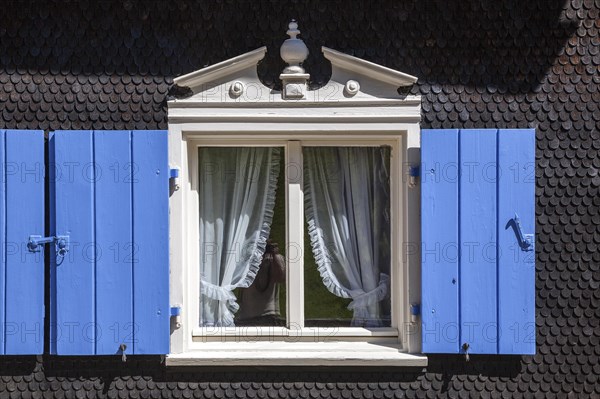 Window with blue shutters on an old farmhouse