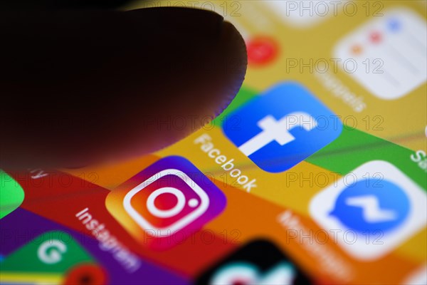 Finger about to press on the Facebook app icon on a smartphone