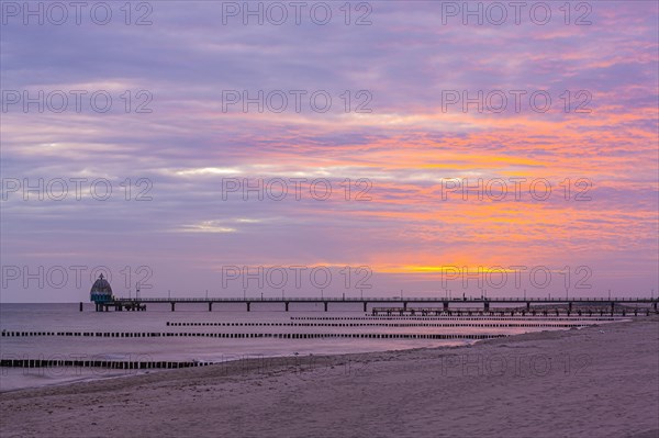 Groyne and diving gondola with pier at the beach of Zingst at sunrise