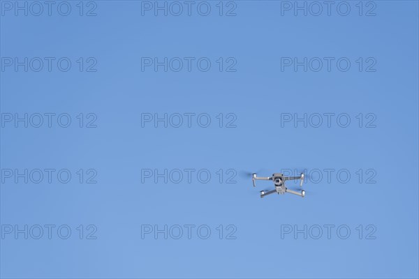 Drone flies in front of blue sky