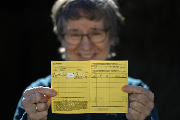 Woman proudly showing her vaccination certificate after being vaccinated with AstraZeneca against Covid-19