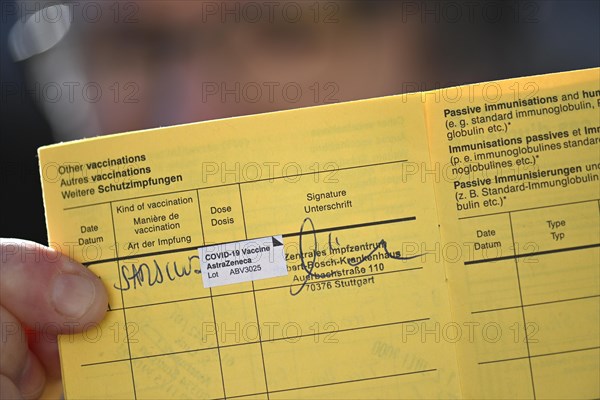 Woman proudly showing her vaccination certificate after being vaccinated with AstraZeneca against Covid-19