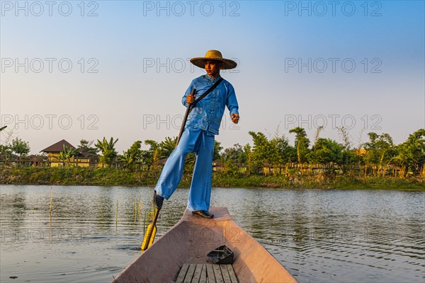 Fisherman at Inle Lake with traditional Intha conical net at sunset
