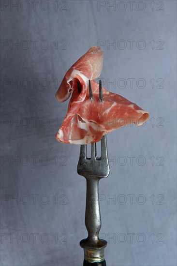 A slice of coppa on fork