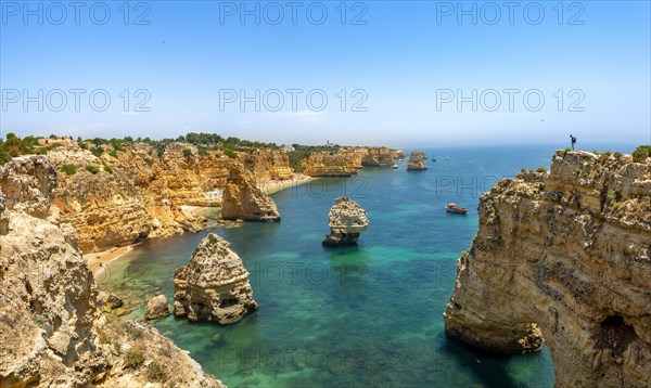 Young man standing on a rock on the cliff