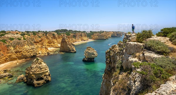 Young man standing on rocks on cliff