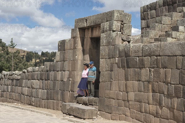 Old indigenous couple posing in the gate of the pyramid of the Incas