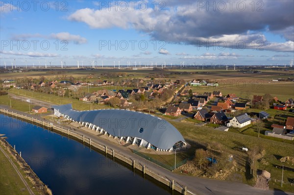 Aerial view of Friedrichskoog Rugenort with view of the indoor playground Willi and the Rugenort Loch in sunlight