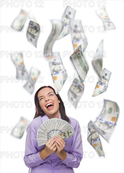 Celebrating young woman holding $100 bills with many others falling around her on white