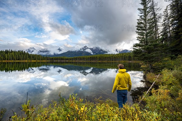 Hiker at the lakeside looking at mountains