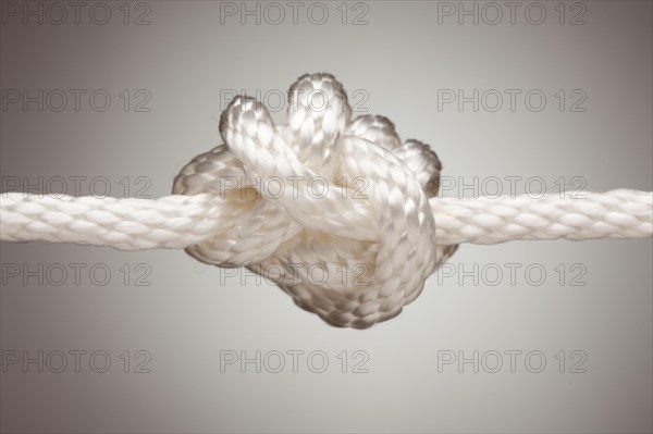Nylon rope knot on a spot lit background