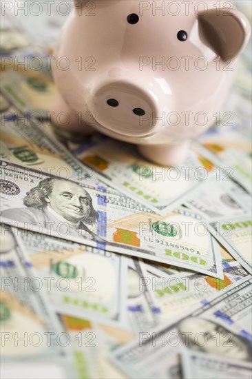 Piggy bank on stacks of newly designed one hundred dollar bills