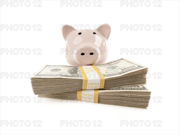 Pink piggy bank with stacks of hundreds of dollars isolated on a white background
