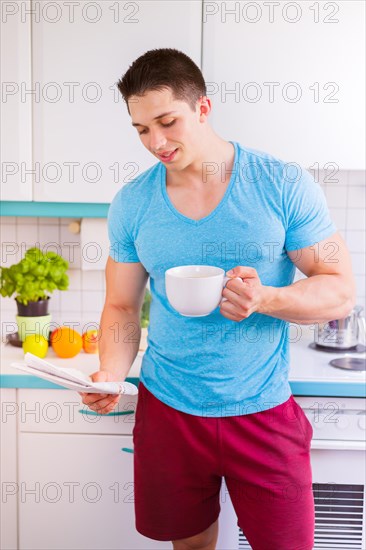 Newspaper reading coffee man reading in kitchen morning laugh in germany