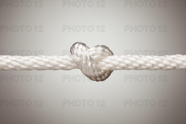Nylon rope knot on a spot lit background