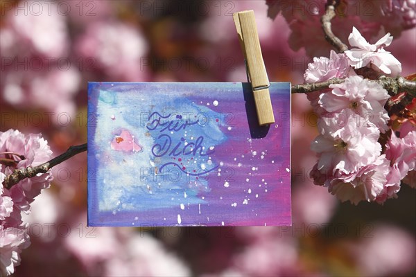Self painted greeting card hanging in tree